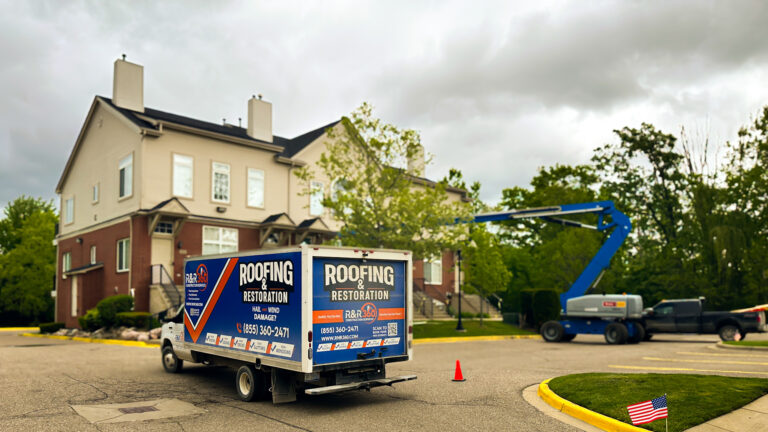 Box truck and boom lift on multifamily roofing restoration at condo complex