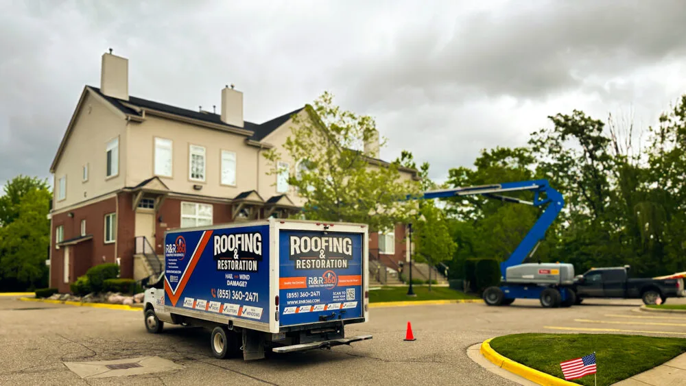 Box truck and boom lift on multifamily roofing restoration at condo complex