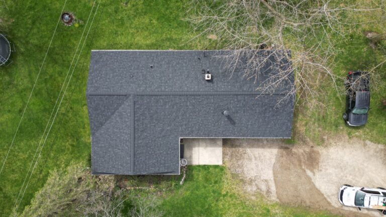 After-install aerial of split-roof home, dual ridge vents visible