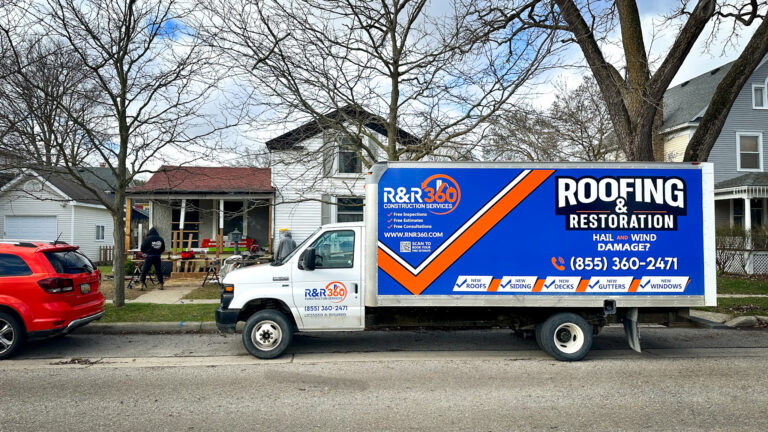 R&R 360 box truck wrapped for roofing & restoration parked at client’s home